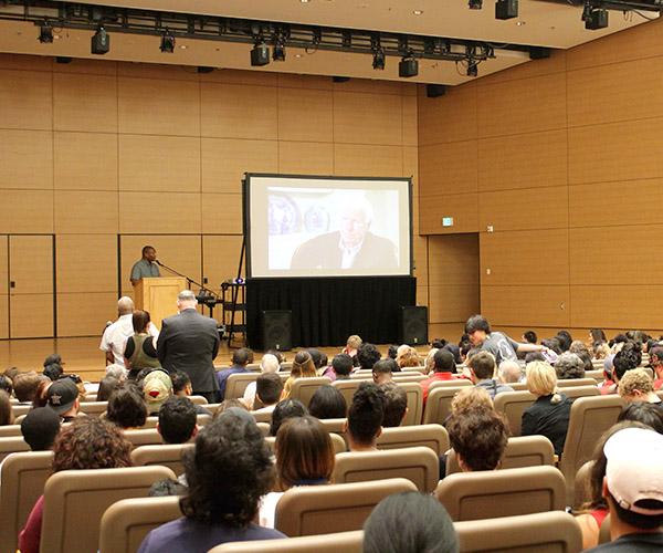 Speaker giving a presentation on his book to a full auditorium