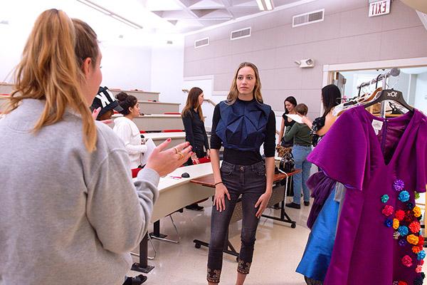 Group of design students looking over a design book during a club meeting